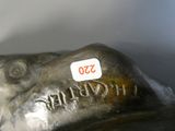 a silver statue of a dog with a tag on it ' s head