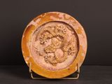 une image représentant une assiette ornée d'un dragon, posée sur un socle