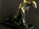 a black and gold statue of an egyptian cat on a black background