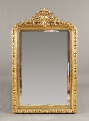 un miroir à cadre doré orné d'un motif décoratif sur le pourtour