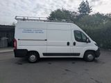 a white van parked in a parking lot with trees in the background
