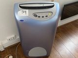 un petit purificateur d'air posé au sol près d'un mur