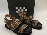 une paire de sandales à imprimé léopard posée devant une boîte