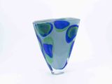 a blue and green vase sitting on a white surface