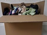 une boîte en carton remplie de vêtements et d'une paire de chaussures