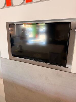 un téléviseur à écran plat fixé au mur d'une pièce