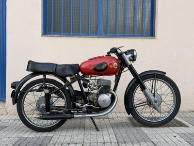 a red and black motorcycle parked in front of a building
