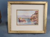 aquarelle encadrée représentant une côte rocheuse avec une maison au loin