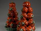 two vases that have tomatoes on them in them