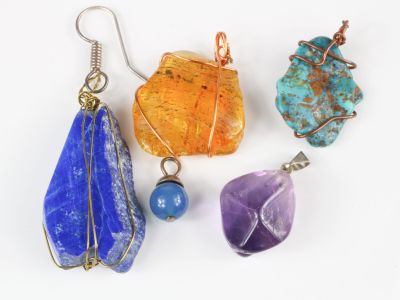 quatre pendentifs en pierre de couleurs différentes sur un fond blanc