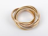 three gold rings stacked on top of each other on a white surface