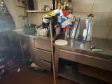 a dirty kitchen with a lot of clutter on the floor