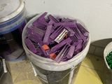 two buckets of purple paint and two buckets of green paint on the floor