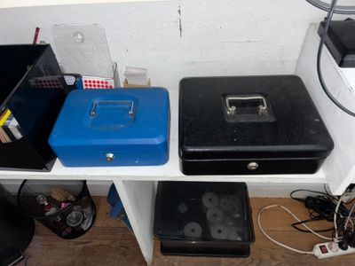 deux valises noires et bleues posées sur une étagère à côté d'un ordinateur
