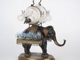 statue d'un éléphant avec une horloge sur le dos, posée sur une table