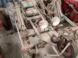 an old tractor with a trailer attached to it in a garage