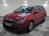la voiture rouge est garée sur un sol en damier dans le garage