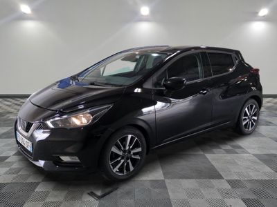 la voiture noire est garée sur un sol en damier dans le garage