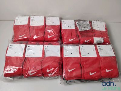 un tas de chaussettes Nike Dri-Fit rouges posées sur une table blanche