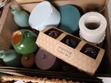 une boîte remplie de tasses et de théières posée sur une table