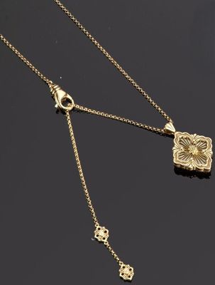 un collier en or avec un pendentif en forme de fleur et une chaîne sur un fond noir