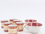 a set of six red and white cups with gold rims
