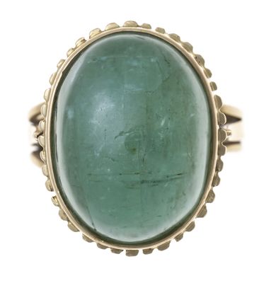 Gros plan sur une bague contenant une pierre verte
