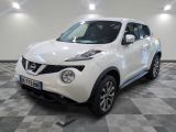 the white nissan juke suv is parked on a checkered floor