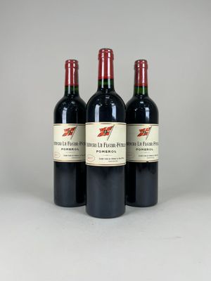 three bottles of red wine sitting next to each other on a table