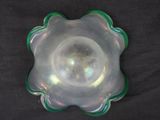 a glass bowl with a green rim on a black surface