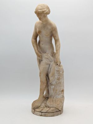 a statue of a boy holding a bag on a white surface