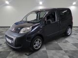 une photo d'une petite camionnette noire posée sur un sol à damier