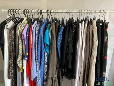 a lot of clothes hanging on a rack in a room