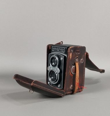 un étui en cuir marron auquel est attaché un appareil photo