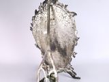 a silver plate with a violin on it on a stand