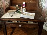 une table en bois sur laquelle se trouvent un livre et une bouteille