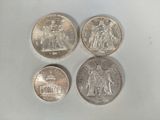 quatre types de pièces différents sont présentés sur une surface blanche