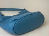 the blue purse is sitting on a white surface