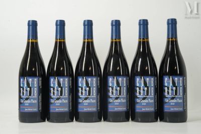six bottles of red wine are lined up on a table