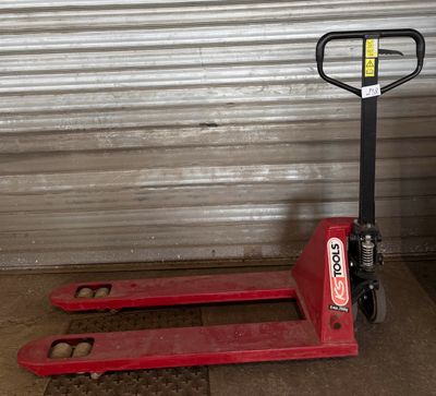 une palette rouge posée devant une porte de garage