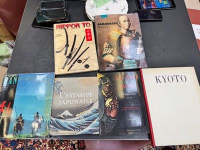 a lot of books on a table with a cell phone on it