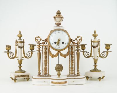 a clock on a stand with three candles and a candle holder