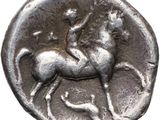an old silver coin with a man riding a horse on it