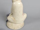 a small figurine of a person sitting on a shell