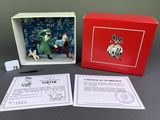 the box contains a miniature figurine of a man and a dog