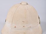 an old, worn helmet is sitting on a white surface