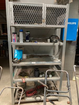 une étagère métallique sur laquelle sont posés de nombreux objets, dans un garage