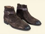 a pair of brown sued boots with a buckle on the side