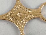 a gold cross that is on a white surface