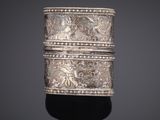 a close up of a silver ring on a black surface